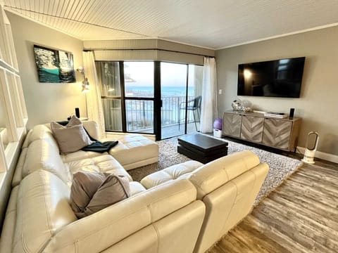 The living room with comfortable furniture and balcony door.