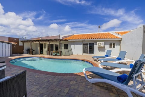 Soak up the Aruban sunshine beside your private swimming pool, complete with sun loungers and a vibrant mural backdrop for the ultimate vacation vibe.