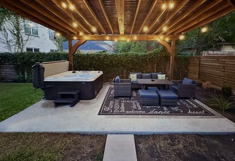 End every evening under the pergola — string lights overhead, hot tub ready, the whole family together after a long day.