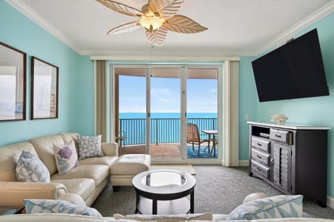 Bright coastal living room with floor-to-ceiling sliders opening to your private ocean-view balcony.