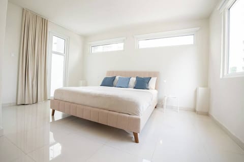 Spacious king bedroom with natural light and cozy bed