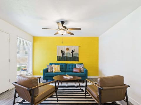 Bright and open living area featuring a smart TV, designer furnishings, and a dining table that seats 2 guests.