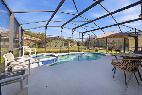 Step outside to relax by your private pool, nestled in a spacious screened enclosure that welcomes fresh air and sunlight. Enjoy the cozy seating area with stylish wicker chairs, ideal for unwinding after a day of adventure.