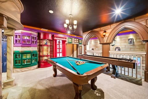 Experience our lively game room with a classic pool table framed by colorful cabinetry and architectural arches. The vibrant decor and warm lighting create an inviting space ideal for socializing and making memories.