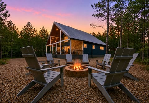Set against a backdrop of tall pines, the cabin’s exterior blends rustic charm with modern comfort in the best way.