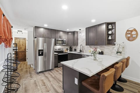 Fully stocked kitchen with stainless steel appliances, quartz countertop and a breakfast and dining area