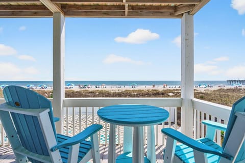 Ocean view from the balcony with two blue chairs and a matching table.