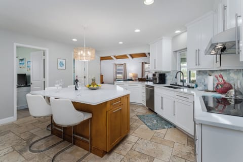Your gourmet kitchen awaits with sleek white counters, modern appliances, and a stunning island perfect for morning coffee or evening wine.