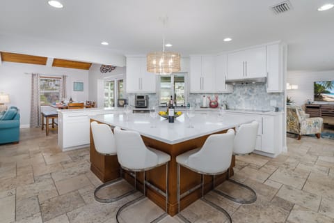 Your spacious open-concept kitchen features modern white cabinets, quartz countertops, and a stunning island perfect for preparing meals together.