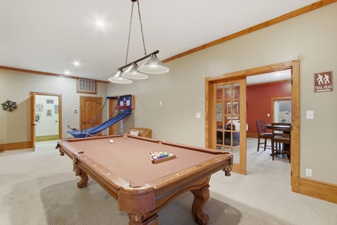 Game room with pool table, arcade hoops, and movie theater beyond