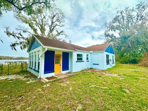 This charming teal lakeside ranch-style home blends vibrant character with laid-back waterfront living, offering the perfect backdrop for relaxing days by the water.