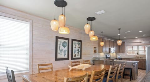 Dining area with a table and chairs set for 8 and additional seating for 4 at the breakfast bar 