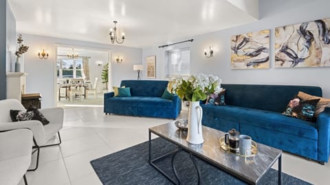 Two dramatic blue three-seater sofas and cosy boucle armchairs let you sit by the fire or watch TV while you sip a drink.