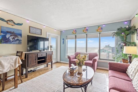 Bright living room with natural light, full-size sofa bed and loveseat, queen sleeper sofa, and direct access to the private balcony with beautiful ocean views.