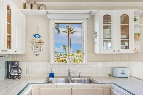 Your bright kitchen overlooks swaying palms and blue skies, making every meal feel like a tropical escape.