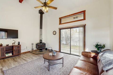 Living room with wood burning fireplace, deck, and flat screen tv