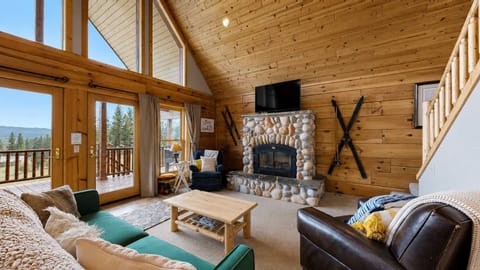 Living room, stone fireplace and TV, mountain views