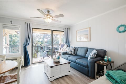 Living area with pull-out queen sofa sleeper and private balcony w/ ocean view.