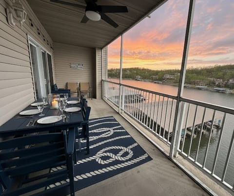 Lakefront condo at Lake of the Ozarks with a spacious screened-in balcony, breathtaking sunset views, outdoor dining, and direct access to the water for the ultimate Ozarks vacation rental experience.