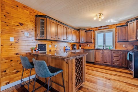 Warm log cabin kitchen with bar seating – perfect for cooking and gathering.