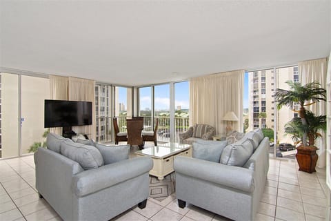 Unwind in your bright living space with plush seating and panoramic city views through floor-to-ceiling windows.