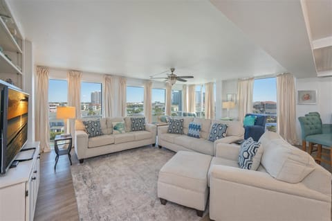Unwind in your spacious living room with panoramic city views through floor-to-ceiling windows and comfortable seating for the whole group.
