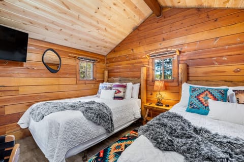 Spacious cabin bedroom with two queen beds—perfect for family or friends staying together.
