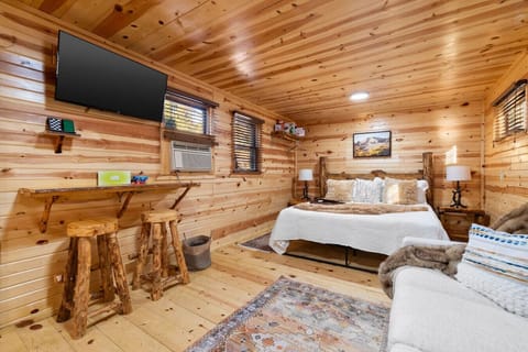 Cozy cabin interior at Black Hills Bungalows with rustic wood finishes, smart TV, and bistro seating, a perfect home base near Mount Rushmore and Rapid City in the Black Hills, South Dakota.