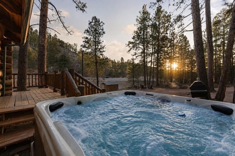 Bubbling hot tub with peaceful pine forest views and golden sunset light at a cozy Black Hills cabin.