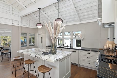 This bright, open kitchen is a chef’s dream. It features a spacious marble island with seating, and high-end finishes that make morning coffee or group dinners feel truly special.