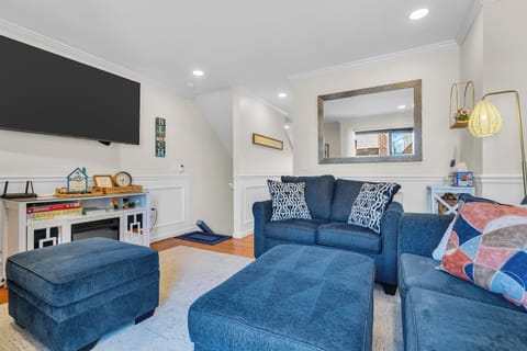 Cozy living room with plush seating, smart TV, and bright stylish decor