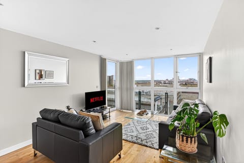 Relax in the cozy living room featuring two comfortable sofas and a smart TV, perfect for unwinding or enjoying your favourite shows.