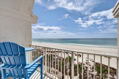 Beachfront balcony with Adirondack chairs and panoramic ocean views.