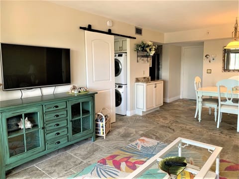 You'll love this bright, open living space featuring charming coastal decor and convenient in-unit laundry tucked behind stylish barn doors.