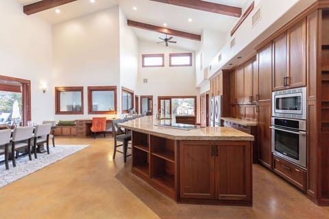Gather in this stunning chef's kitchen with soaring ceilings, warm wood details, and a spacious island perfect for cooking meals together.