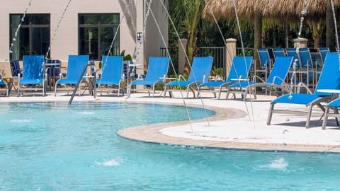 Relax poolside on vibrant blue loungers, surrounded by a refreshing aquatic oasis.