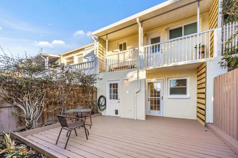 Spacious outdoor deck with seating and upper balcony access