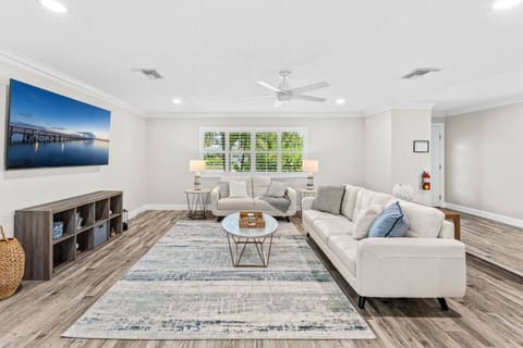 Spacious living room with modern furnishings and natural light from large windows.