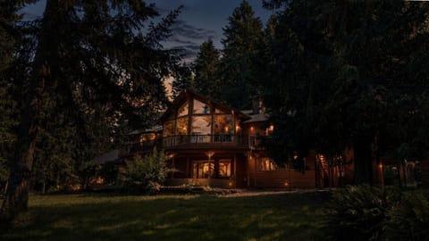 Twilight view of Hurricane Hideaway surrounded by towering evergreens.