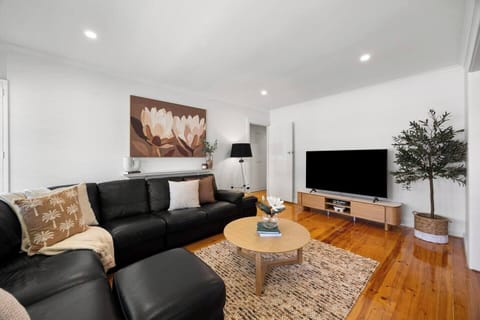 Unwind in the light-filled living area, where plush seating and a TV create an easy space to stream your favourite shows after a day at Glenelg Beach.