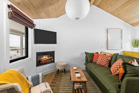 Cozy up in this inviting living space featuring a gas fireplace, smart TV, and comfortable seating—perfect for relaxing after a day exploring the area. The warm wood ceiling and large window create a bright.