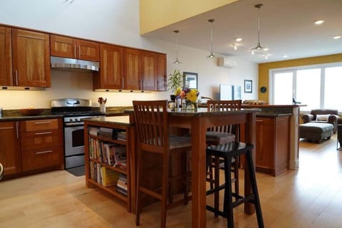 Bright, open kitchen for gathering 🍽️

This spacious kitchen features warm wood cabinetry, modern appliances, and a large island perfect for cooking, dining, or sharing a glass of wine. With the living area just steps away, it's an inviting space for meals, conversation, and time together.