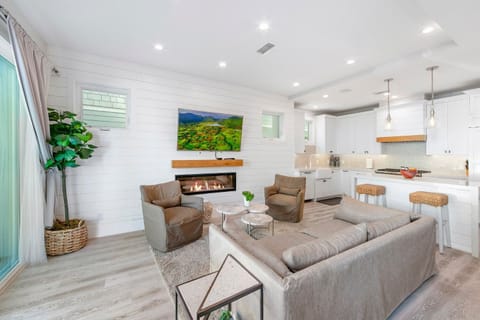 Bright, modern living area with a plush sectional sofa, stylish coffee table, and natural light throughout — ideal for unwinding after a day at the beach.