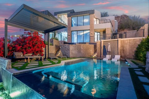 Relax poolside in the private resort-style backyard featuring a sparkling pool, lounge seating, and covered patio.