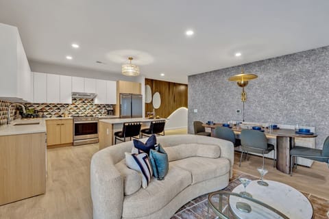 Unit 1: Bright open living space featuring smart flat-screen TV, designer furnishings, and access to a large corner private balcony.