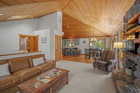 Relax in this cozy living room with vaulted wood ceilings, leather seating, and a stone fireplace creating the perfect mountain retreat atmosphere.