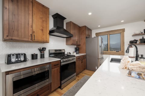 Your fully equipped kitchen awaits with warm wood cabinetry, stainless steel appliances, and everything you need to create memorable meals.