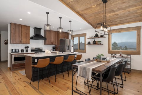 Your open kitchen flows seamlessly into the dining area, where rustic beams meet modern comfort for memorable mountain meals.