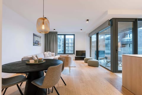 A warm, open-plan living space with a fully equipped kitchen and a dining table for four