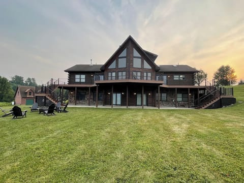 The backyard of this gorgeous log cabin is a dream in winter or summer with a full wraparound porch, fire pit, and double staircases. 